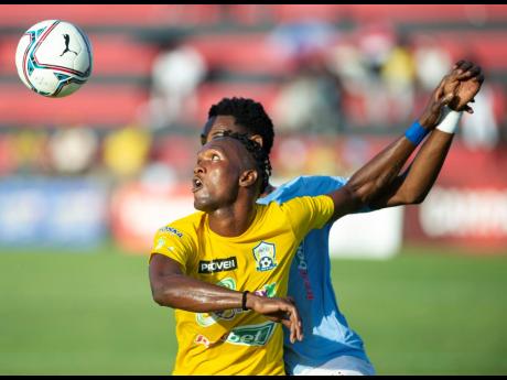Molynes United’s Damion Thomas (front) is challenged by Waterhouse’s Jahvon James during a Jamaica Premier League game at the Anthony Spaulding Sports Complex in Kingston on Monday, May 2.