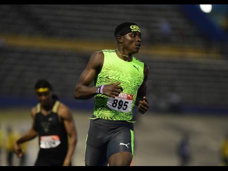 Sandrey Davidson looks to the clock to see that he became the 200m champion in 20.84 seconds at the JAAA National Junior Championships at the National Stadium in Kingston last night.