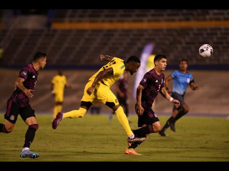 Jamaica’s Junior Flemmings (centre) takes a headed shot on goal during their Concacaf Nations League game against Mexico at the National Stadium in Kingston on Tuesday, June 14.