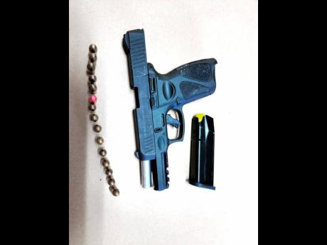 The black taurus 9mm semi-automatic pistol which was seized at the house occupied by the woman and her two sons in Duncans, Trelawny, on Tuesday morning.