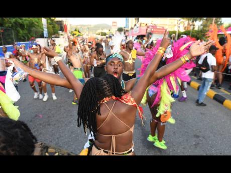 Revellers in the Bacchanal band are animated as they march along Trafalgar Road on Sunday.