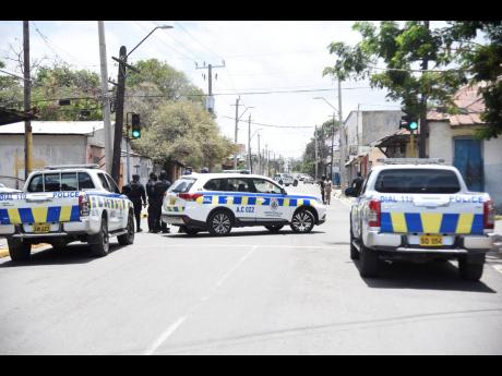 Investigators at the scene of yesterday’s murder in downtown Kingston. 