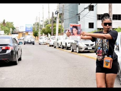 Credit: Ian Allen Regina Richards, a friend of Donna-Lee Donaldson, holds up a poster of the former 876 Roommates host who has been missing since last Wednesday.