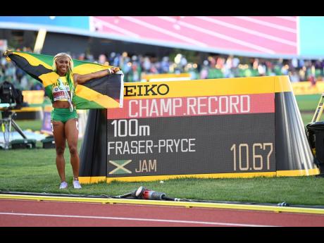 Shelly-Ann Fraser-Pryce poses with the stadium clock at Hayward Field, after setting a championship record of 10.67 seconds to win her fifth World 100m title at the World Athletics Championships in Eugene, Oregon, yesterday.