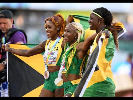 WORLD BEATERS: Shelly-Ann Fraser-Pryce (centre) ran a championship record 10.67 seconds in Eugene, Oregon, to win the 100 metres at the World Championships last night. Her compatriots  Shericka Jackson (right) ran 10.73 for the silver and Elaine Thompson-Herah (10.81) got the bronze.