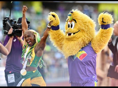 World Champion Shelly-Ann Fraser-Pryce (left) celebrates with Legend the Bigfoot, the mascot of the IAAF 2022 World Athletics Championships, after winning the 100-metres in Oregon, USA last night.