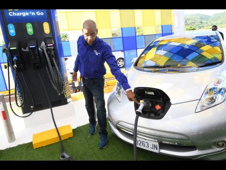 Richard Gordon, manager of business development at the Jamaica Public Service Company, charges an electric vehicle during the commissioning of the first public electric vehicle charging station at Boots service station in Drax Hall, St Ann last May.