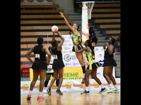 Jamaica’s Shamera Sterling (centre) is hoisted by teammate Latanya Wilson as she defends against a shot by Trinidad and Tobago’s Kalifa McCollin during a Sunshine Series Test match at the National Indoor Sports Centre in Kingston on Tuesday, October 19, 2021.