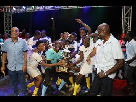 Venom FC, of Gravel Hill in Clarendon, celebrate with the trophy after winning the Alliance Financial Services Porus Football Festival final.