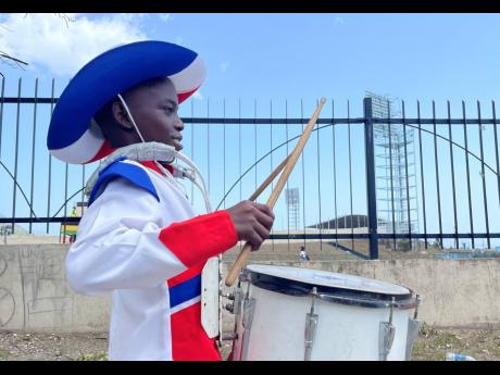 Credit: Gladstone Taylor Despite his height, Tayshawn Spence stands tall as he drums away. The 13-year-old, who is a member of the Eagles Drum and Bugle Core, was out with his fellow musicians at the Emancipation Day Float Parade yesterday.