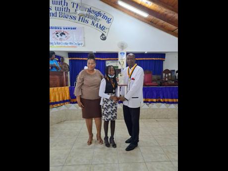 Photos by Rasbert Turner 
Claude Beecher (right) presents the trophy for top PEP score to Shamala Morris of Horizon Park Primary School. Looking on is the school’s principal, Shernette King-Nicholas.