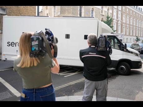 Journalists film a prison van moving into Westminster Magistrates Court in London on Wednesday. A 20-year-old man has been charged with intending to injure or alarm the queen under the Treason Act following an incident on Christmas Day 2021 at Windsor Castle. 