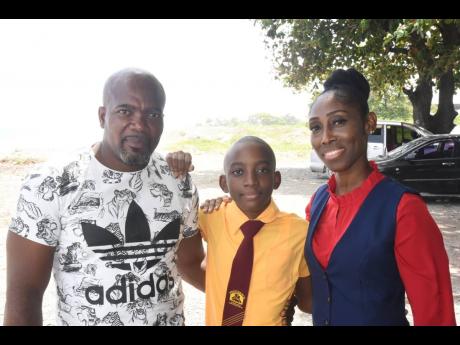 Tahier Fagan (centre) is flanked by his loving parents, Mark Fagan and Tamara Deans-Fagan.