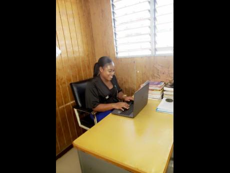 A relaxed Joet Lovelace enjoys herself while working on a work plan for her students.