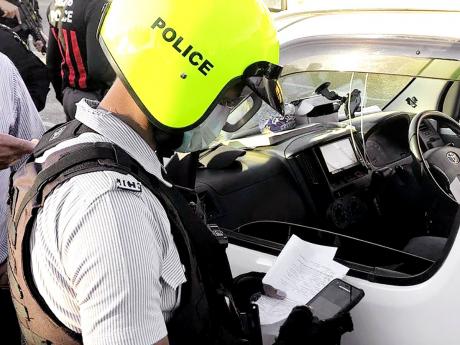 A policeman utilises the new e-ticketing system to check a motorist’s car documents.