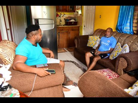 David (left) and his father Delroy Ricketts at their home in Clarendon, three months after the senior Ricketts underwent brain surgery.
