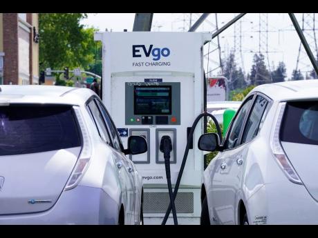 Electric cars are parked at a charging station in the USA. Jamaica has reduced the duty on the importation of these vehicles.