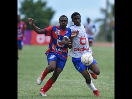Camperdown’s Ramone Francis (left) and Trevaughn Rennie of Hydel battle for possession during their ISSA/Digicel Manning Cup match at Stadium East yesterday. The match ended 1-1.