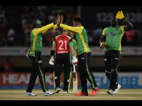 Mohammad Amir (centre) of Jamaica Tallawahs celebrates with teammates after getting the wicket of Paul Stirling of Guyana Amazon Warriors during qualifier two in the Caribbean Premier League (CPL) at Providence Stadium yesterday, in Georgetown, Guyana.