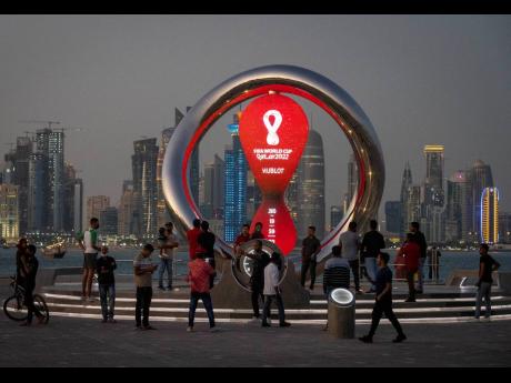 People gather around the official countdown clock showing remaining time until the kick-off of the World Cup 2022, in Doha, Qatar, in November. Fans going to the World Cup in Qatar must show a negative COVID-19 test when they arrive as part of the host nation’s rules to combat COVID-19, organisers said yesterday.