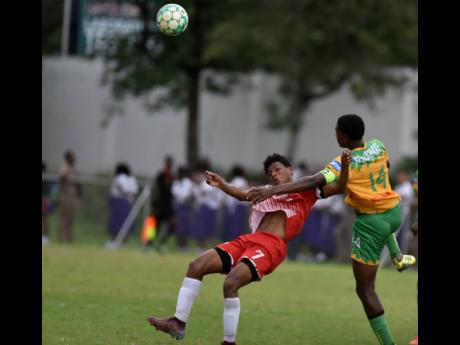 Excelsior High’s Antwan Johnson tackles Campion High’s Kai Myles during their ISSA/DIGICEL Manning Cup match at Campion yesterday. The match was stopped by the referee because of heavy rain.