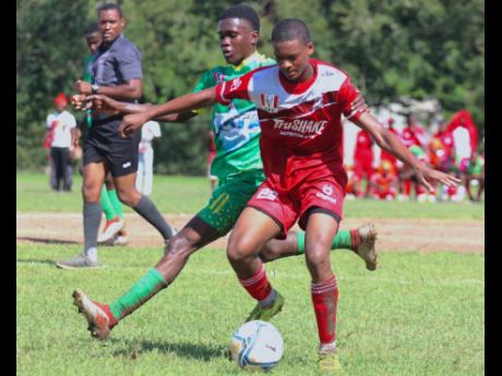 Glenmuir’s Nuemonie Blackwood protects the ball from the incoming Mario Miller of Old Harbour High during their ISSA daCosta Cup Group M encounter at Port Esquivel yesterday. Glenmuir won 2-0.