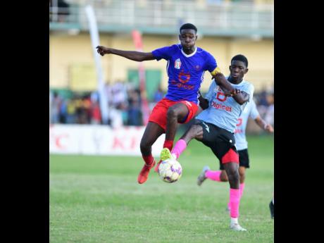 Camperdown’s Devante McCrea (left) and Adriano Vassell of Mona battle for possession of the ball during their ISSA/Digicel Manning Cup football match at Excelsior High School in St Andrew yesterday. Mona won 4-3.