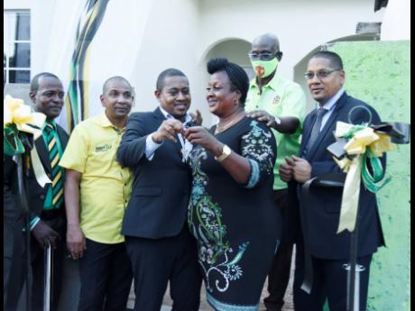 Julia Rogers (third right) receives the keys to her new home from Floyd Green, minister without portfolio in the Office of the Prime Minister. Looking on are (from left) Orlando Walters, representing Rosalie Hamilton, councillor of the Rae Town Division; Kingston’s Mayor Senator Councillor Delroy Williams; Local Government and Rural Development Minister Desmond McKenzie; and Donovan Williams, member of parliament for Central Kingston.