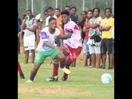 Credit: Ashley Anguin William Knibb’s Mark Lewis (left) battles Spot Valley High’s Javane Clarke during an ISSA/Digicel daCosta Cup match at William Knibb recently. William Knibb won 3-0.