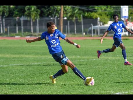 Kevaughn Wilson of Jamaica College scores to complete his hat-trick against Holy Trinity High School during the ISSA/Digicel Group B Manning Cup match at Ashenheim Stadium Jamaica College yesterday.