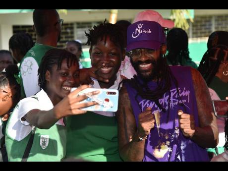 Morant Bay High School students take a selfie with singer Tarrus Riley.