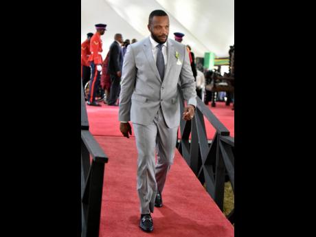 Credit: Kenyon Hemans Jeffrey Ethan ‘Agent Sasco’ Campbell returns to his seat after receiving the Order of Distinction in the rank of Officer for his contribution to music, philanthropy and pro-social messaging to youth.