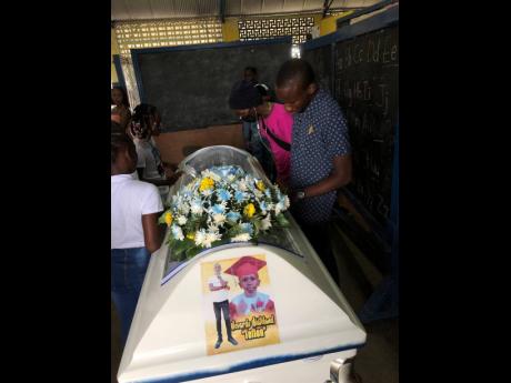 Mourners look at the body of Nevardo Mateland at his funeral yesterday in Trench Town.