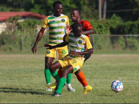 Tivoli Gardens’ Shaquille Jones is sandwiched by Vere United’s Shamar O’Connor (right) and Kayon Henry during their Jamaica Premier League opening match at the Wembly Centre of Excellence yesterday. The match ended in a 1-1 draw.