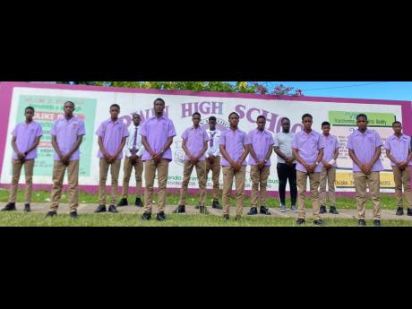 Credit: Contributed Mentor Fabian Kelvin (centre grey and black) stands with his players at the school.