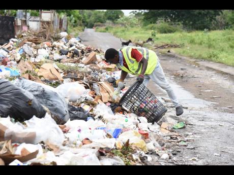 Ricardo Osbourne rummages through rubbish looking for bottles that he can recycle.