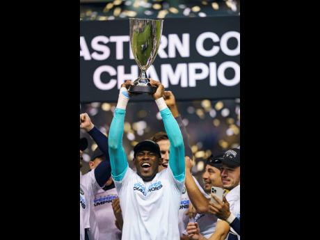 Credit: AP Philadelphia Union’s Andre Blake raises the trophy after they defeated New York City FC in the MLS Eastern Conference final on Sunday. The Union won 3-1.
