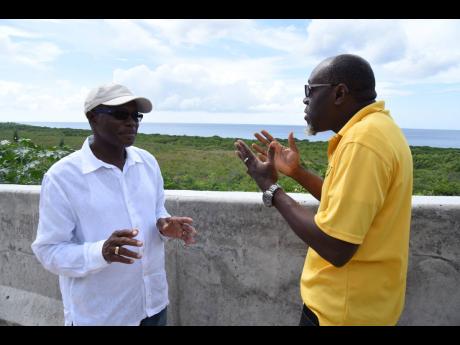 Everald Warmington (left) minister without portfolio in the Ministry of Economic Growth and Job Creation is in a lively discussion about the roads in St Thomas with Stephen Shaw, manager, communication and customer service at the National Works Agency, during a tour of sections of St Thomas Western.