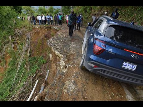 Credit: Ian Allen/Photographer A motorist drives perilously close to the edge of an eroding roadway in Mount Vernon Gap, St Thomas Western, on Wednesday.