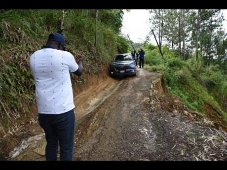 Credit: Ian Allen A motorist makes his way along the narrow roadway in Mount Vernon Gap in St Thomas where the road was impacted by a landslide.