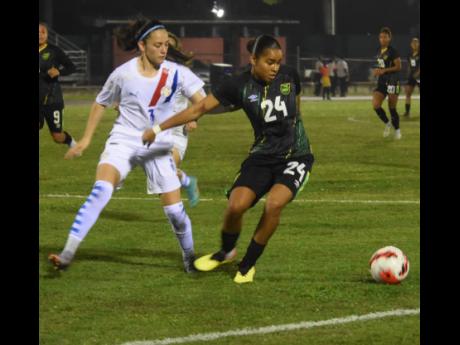 Jamaica’s Shania Hayles (right) shields the ball from Paraguay’s Maria Martinez in their friendly international at the Montego Bay Sports Complex yesterday. The Reggae Girlz won the match 1-0.