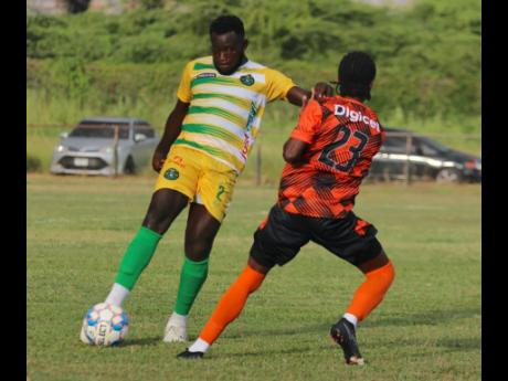 Ricardo Campbell (left) makes a clearance before being challenged by Tivoli Gardens’ Trevaune McKain during their Jamaica Premier League (JPL) match at Wembley Centre of Excellence recently. The match ended in a 1-1 draw.