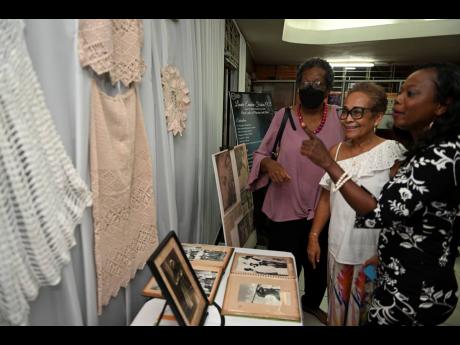 Credit: Ricardo Makyn From left: Cara Lewis, Ruth Ho Shing and Angela Jarrett check out pieces done by the late Leonie Forbes during a tribute concert at the Little Theatre on Monday.