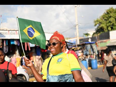 Credit: Gladstone Taylor A Brazil supporter shows off her jersey and flag in downtown Kingston on Thursday.