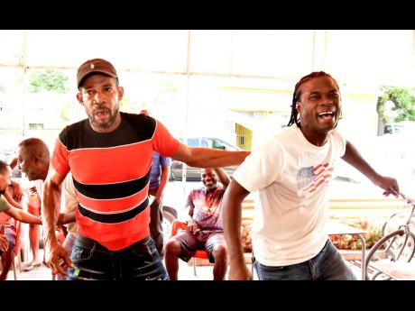 Credit: Kenyon Hemans Argentina supporters Shabba (left) and Shawn celebrate their team’s second goal at Sonia’s Place on the Terrace in St Andrew. The South American giants had lost their first game to Saudi Arabia.