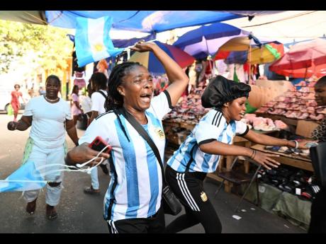Argentina supporters on Beckford Street celebrate their team’s second goal yesterday in the win over European opponents Poland.