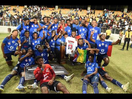 Jamaica College players celebrate with the ISSA/Digicel Manning Cup schoolboy football trophy after defeating St Andrew Technical High School (STATHS) 8-7 on penalties in the final on Friday night at Sabina Park. The scores were tied 1-1 at the end of regulation time.