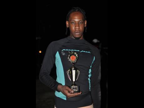 Dancehall artiste Topmann, a former student of The University of the West Indies, poses with the winning trophy following Friday’s celebrity game. 