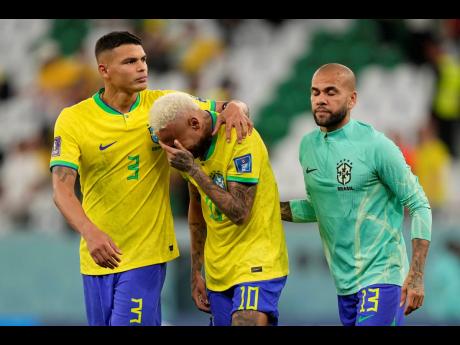 Brazil players Thiago Silva (left) and Dani Alves (right) console Neymar after their World Cup quarter-final defeat to Croatia last Friday. 