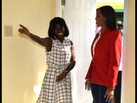 Welcome! Sidoney Eldemire (left) is overcome with emotion as she invites Ashley Horne, managing director of ARC Properties Limited into her new home. ARC built the dwelling.
